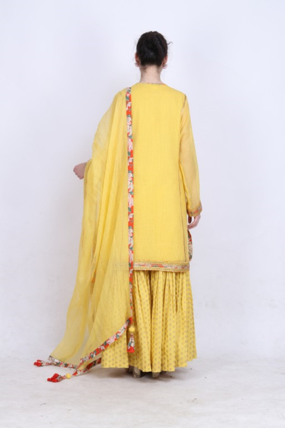 Pitambari yellow kota doria kurta with a gold foil printed gathered sharara and kota doria dupatta.