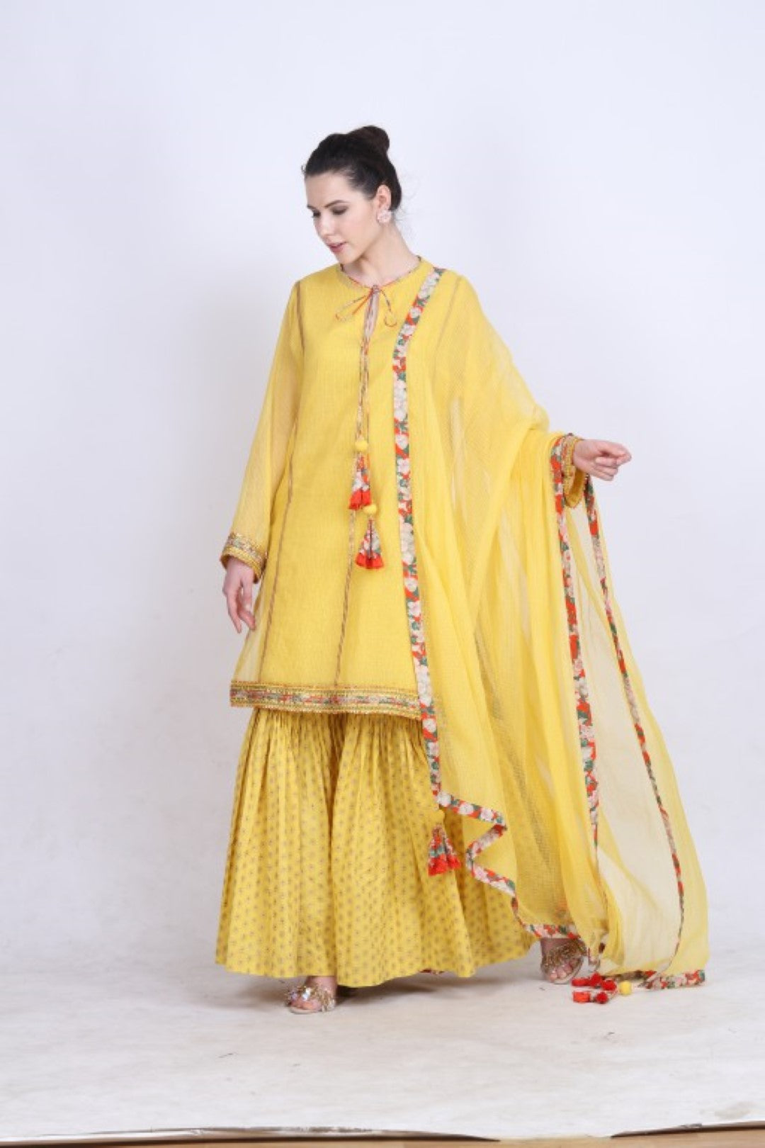 Pitambari yellow kota doria kurta with a gold foil printed gathered sharara and kota doria dupatta.