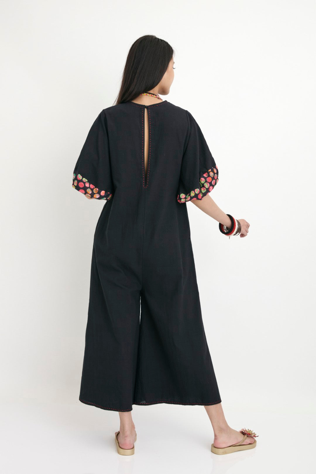 "Handwoven black color solid jumpsuit with black polka dot detail with french knots and 3D flower detail.  100% Handwoven silk; Lining: cotton  100% Azo Free Dry Clean Only"