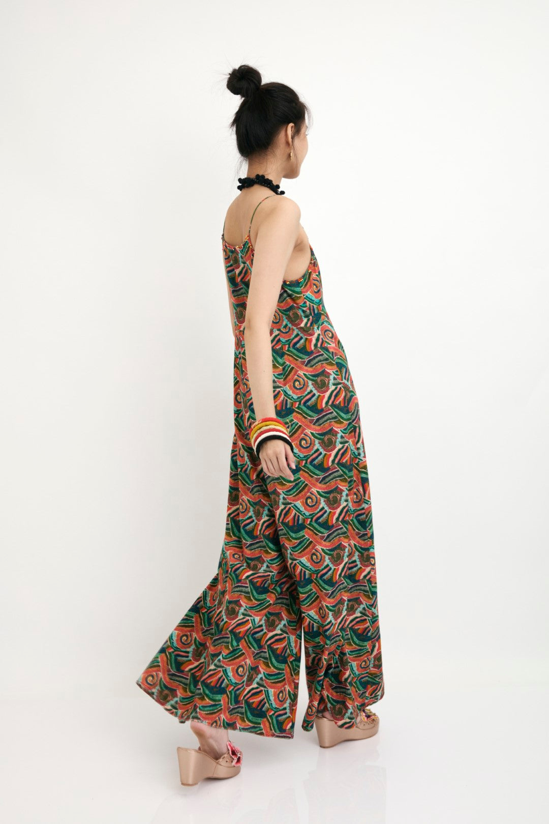 "Hand-painted iconic ocean-wave strap detail jumpsuit with hand embroidery french knots and flower detail.  100% Handwoven cotton 100% Azo Free Dry Clean Only"