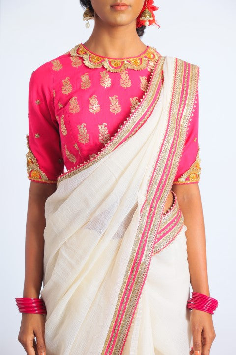 IVORY HANDWOVEN KOTA DORIA SAREE PAIRED WITH FUSCHIA PINK SIGNATURE MUGHAL BUTA PRINT BLOUSE.