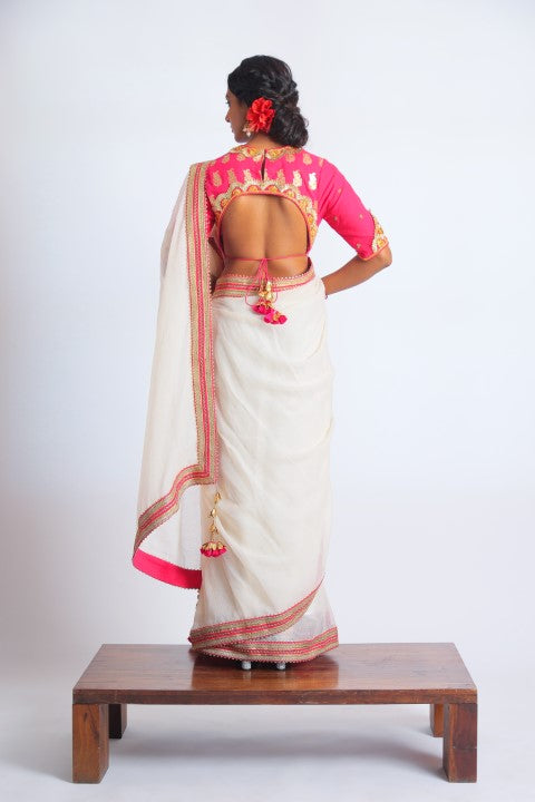 IVORY HANDWOVEN KOTA DORIA SAREE PAIRED WITH FUSCHIA PINK SIGNATURE MUGHAL BUTA PRINT BLOUSE.