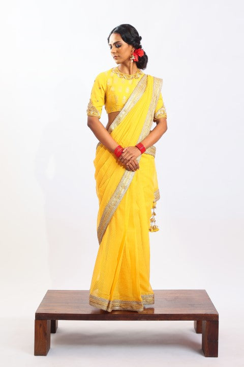 PITAMBARI YELLOW KOTA DORIA SAREE PAIRED WITH MATCHING SIGNATURE MUGHAL BUTA PRINT BLOUSE.