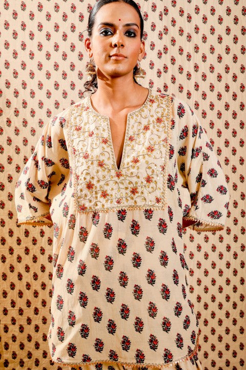 BEIGE KURTA PAIRED WITH SALWAR PANTS AND SCARF.