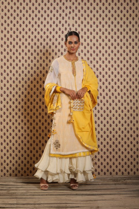 IVORY AND PITAMBARI YELLOW SIGNATURE LAYERED KURTA PAIRED WITH DOUBLE LAYERED SHARARA AND COTTON DUPATTA.