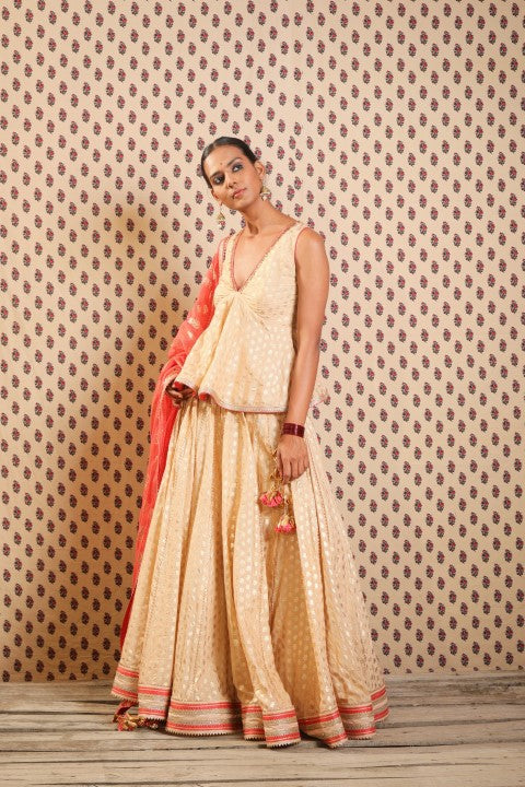 LIGHT CAMEL PEPLUM BLOUSE PAIRED WITH LOTUS PRINT LEHENGA DUPATTA.