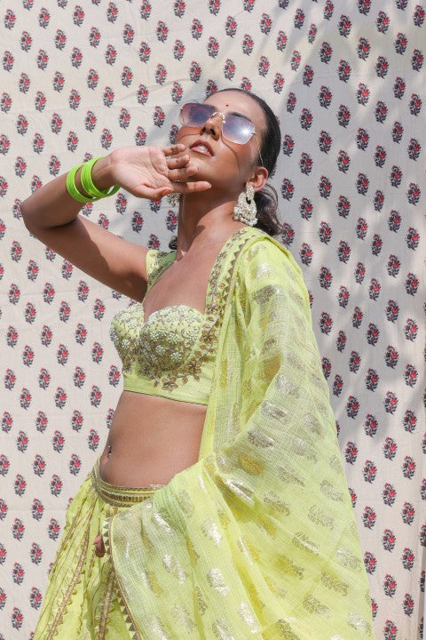 LIME GREEN COTTON SILK BLOUSE PAIRED WITH ORGANDI LEHENGA AND KOTA DORIA DUPATTA.