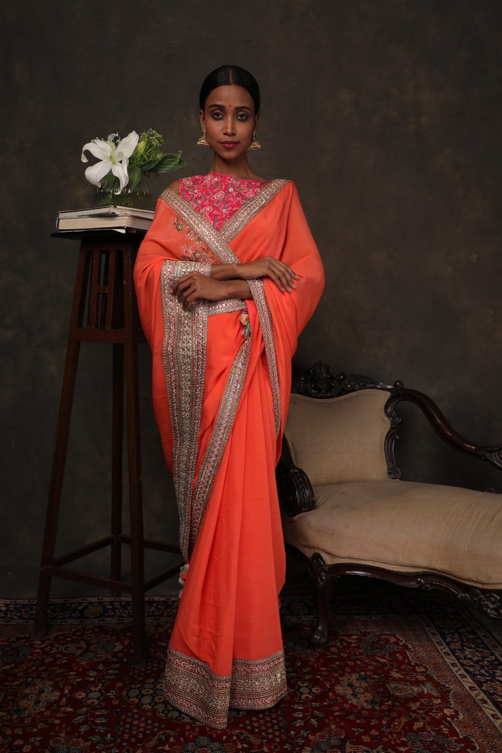 Coral crepe saree with a thread work rani pink blouse.