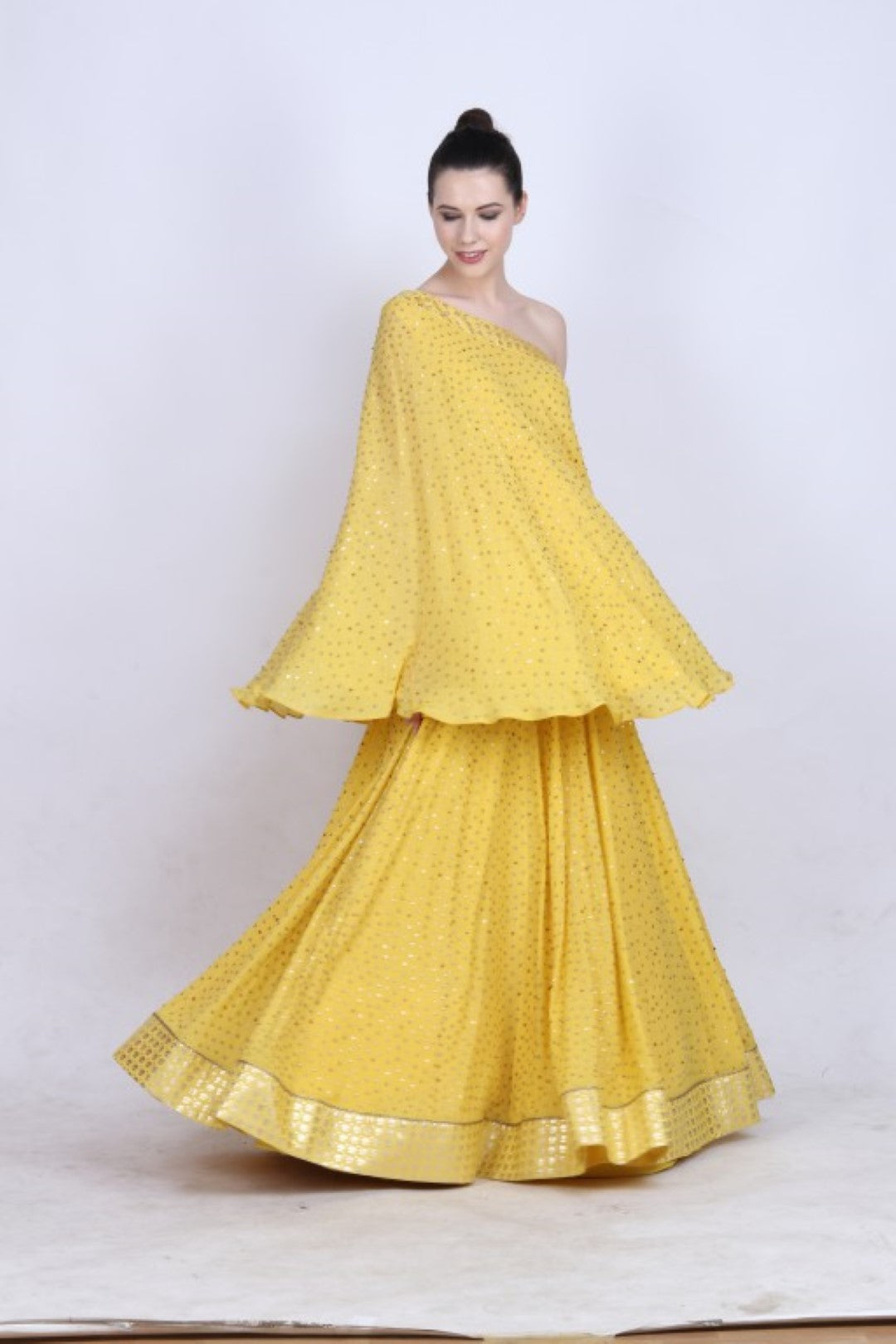 Pitamabari yellow crepe one shoulder top with a heavy cheeta work skirt and mukesh net embroidered dupatta.
