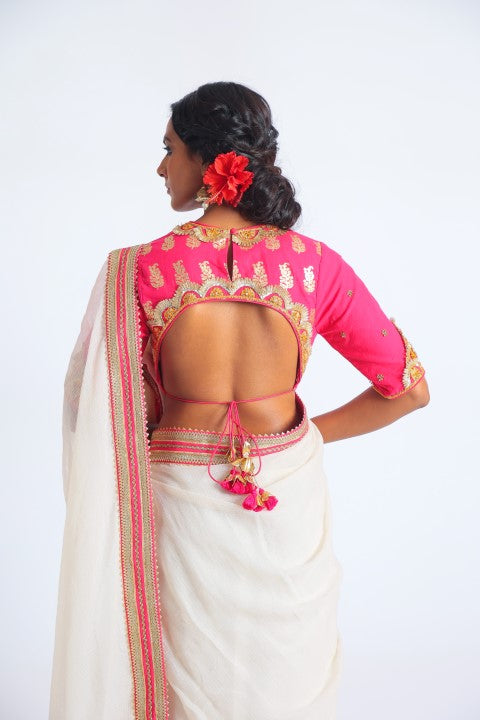 IVORY HANDWOVEN KOTA DORIA SAREE PAIRED WITH FUSCHIA PINK SIGNATURE MUGHAL BUTA PRINT BLOUSE.