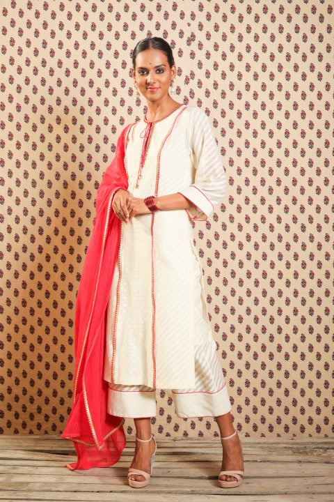 IVORY HANDWOVEN CHANDERI STRAIGHT KURTA PAIRED WITH MATCHING PANTS AND SINDOORI RED KOTA DORIA DUPATTA.