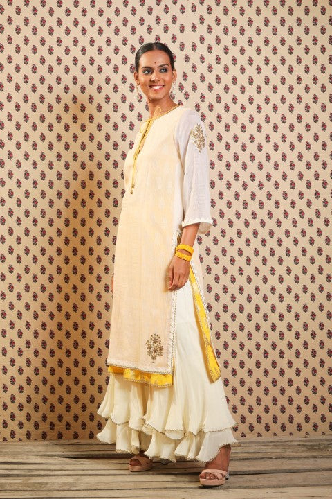 IVORY AND PITAMBARI YELLOW SIGNATURE LAYERED KURTA PAIRED WITH DOUBLE LAYERED SHARARA AND COTTON DUPATTA.