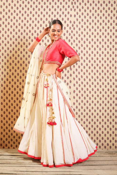 SINDOORI RED RAW SILK BLOUSE PAIRED PAIRED WITH HAND CRUSHED COTTON LEHENGA AND IVORY HANDWOVEN JAMDANI DUPATTA.