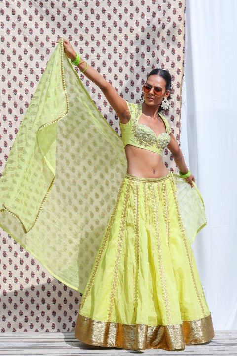 LIME GREEN COTTON SILK BLOUSE PAIRED WITH ORGANDI LEHENGA AND KOTA DORIA DUPATTA.