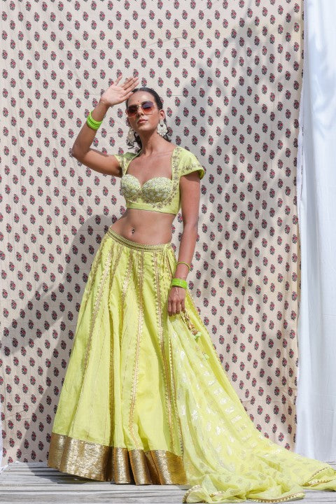 LIME GREEN COTTON SILK BLOUSE PAIRED WITH ORGANDI LEHENGA AND KOTA DORIA DUPATTA.