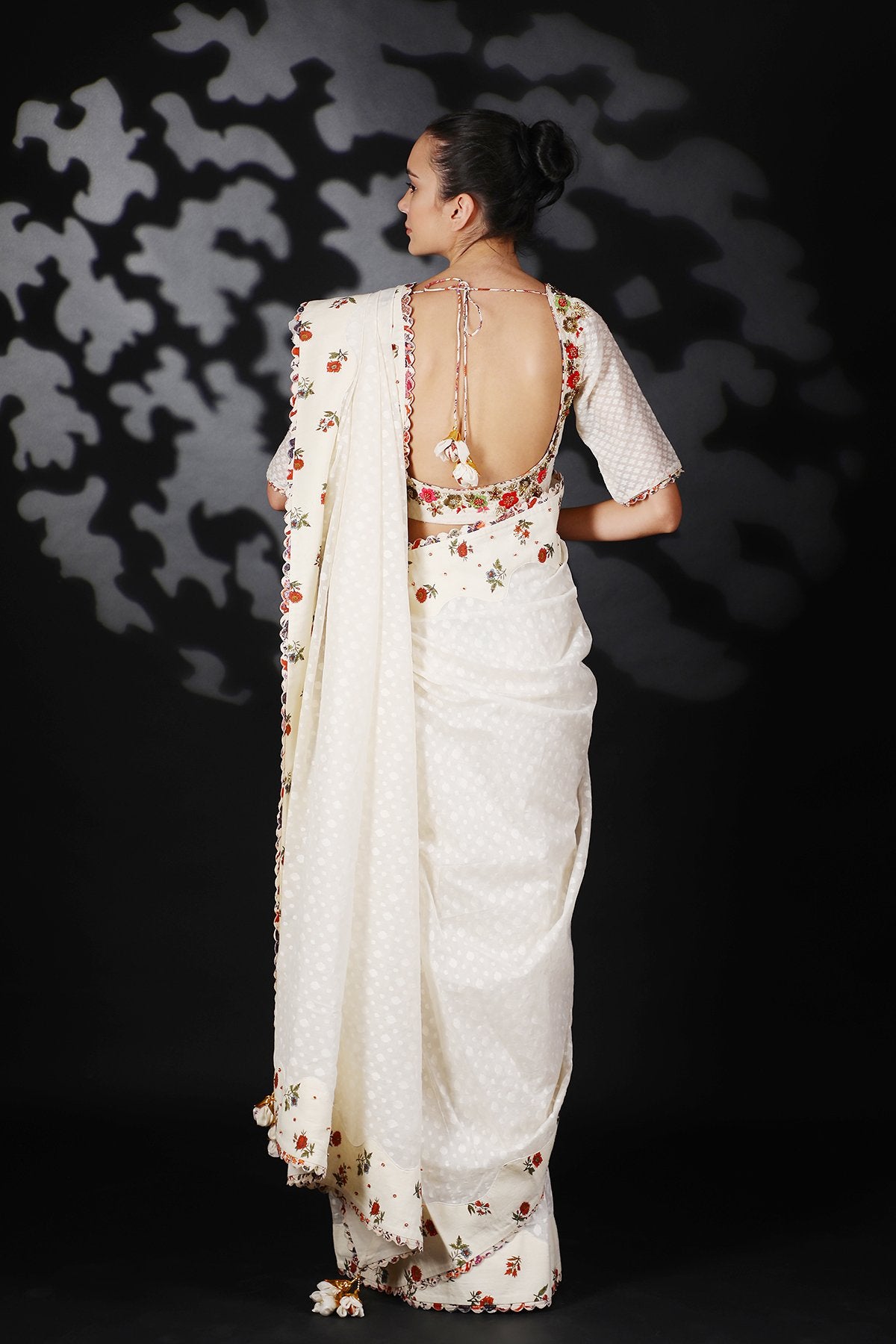 Lilly Off White Handwoven Cotton Jamdani Saree Paired with a hi-neck Blouse with Floral Hand Embroidered Neckline.